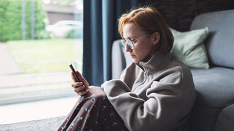Mid adult woman sitting with mobile at home