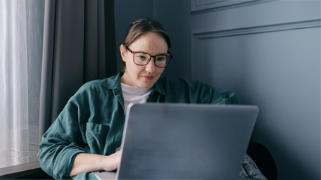 Middle-aged woman freelance works at home with a laptop