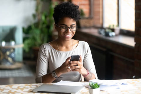 Young Mixed Race Woman Looking At Iphone